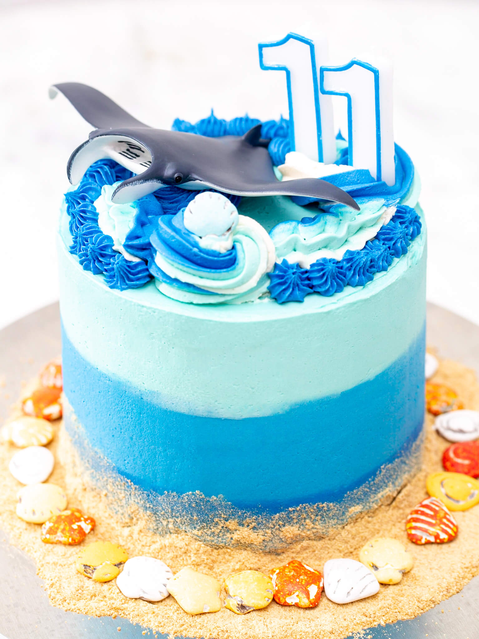 A toy manta on the top of a blue underwater-themed birthday cake