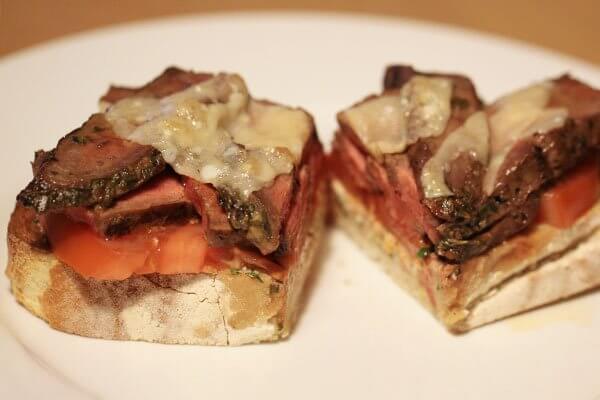 Open-face flank steak sandwich with goat cheese and tomato