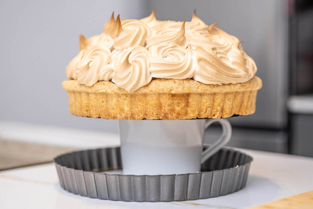 Using a coffee mug to remove a tart from a tart pan with removable bottom