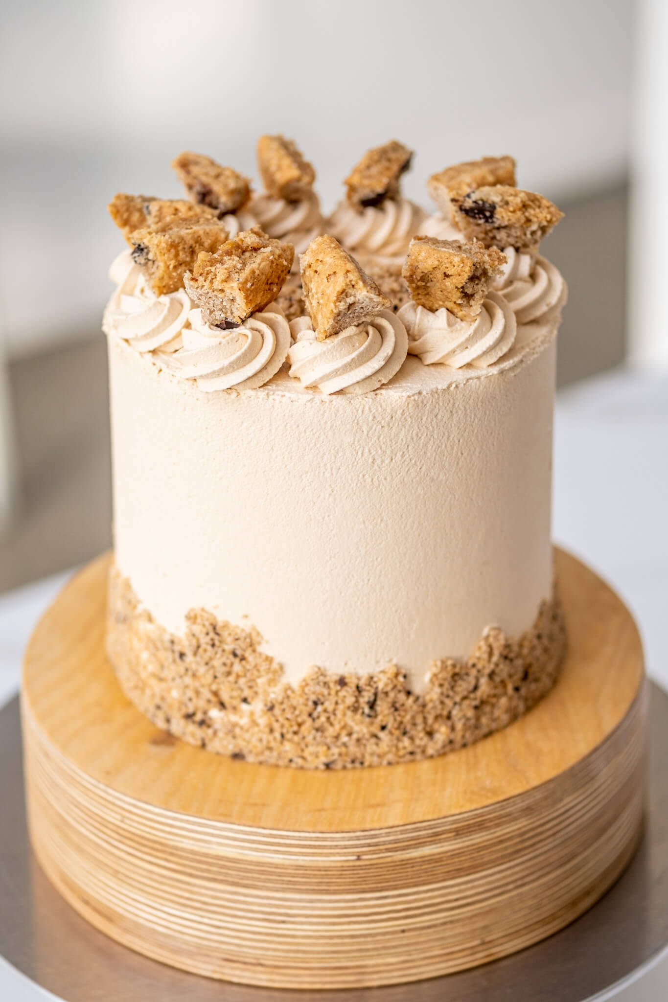 Vegan layer cake with Biscoff-flavoured buttercream icing and decorated with chunks and crumbs of oatmeal-chocolate cake.