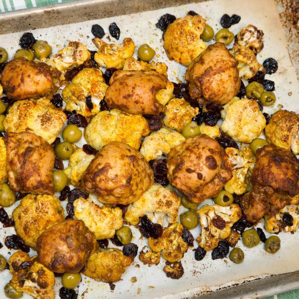 Curried chicken thighs with cauliflower, dried cranberries and olives