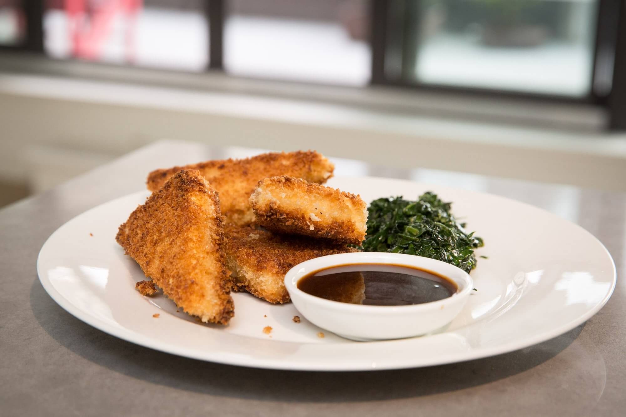 Crispy fried breaded tofu with hoisin dipping sauce and spinach